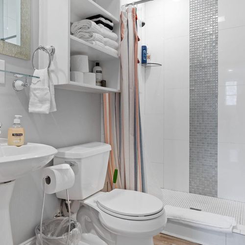 Bright first floor bathroom w/ shower & fresh, tidy layout.