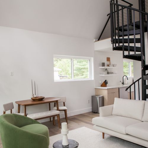 Living room seating area and spiral staircase.