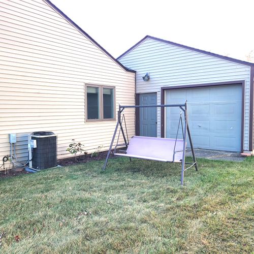 EXTERIOR:  The charming swing behind the garage, with a lovely view of Lake Huron.  (Note that the central A/C unit is also shown in the photo.)