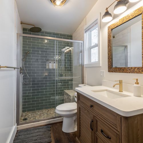 Spacious bathroom with walk-in shower, toilet, and large vanity sink.