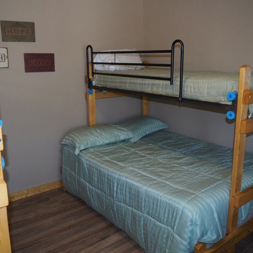 Main room:  features a small dining table with chairs, kitchenette  / sink, one twin-on-full bunk bed, and one twin-on-twin bunk bed.