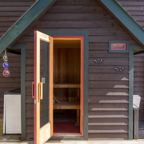 Cedar Finnish Sauna with an electric heater with rocks.  Easily seats four with head rests and water bucket.
