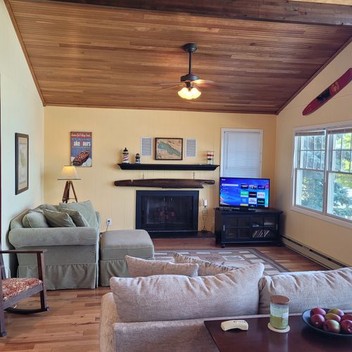 LIVING ROOM #1 (SECOND FLOOR):  The cottage has a large and comfy living room with a streaming television and a great view of Crystal Lake.  Note that the fireplace is not available for guest usage though.