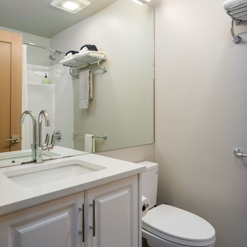 Guest bathroom ensuite with a shower/tub combo and single vanity.  Natural shampoo, conditioner, soap, and quality towels are provided.
