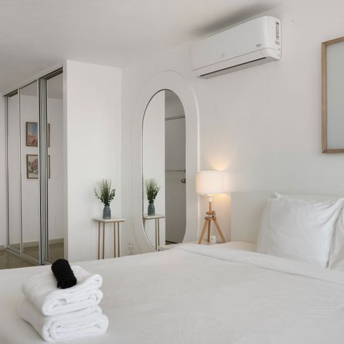 Chic bedroom with elegant archway and mirror. Get ready in style and comfort.