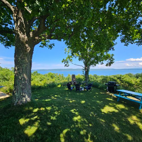 OVERVIEW:  The outdoor hot tub, grill, bonfire ring, and picnic table with Crystal Lake in the background.