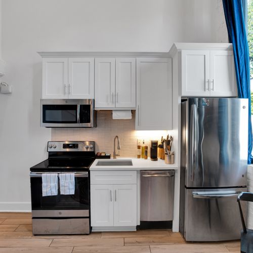 Bright, well-equipped kitchen w/ stainless steel appliances & classic white cabinetry.