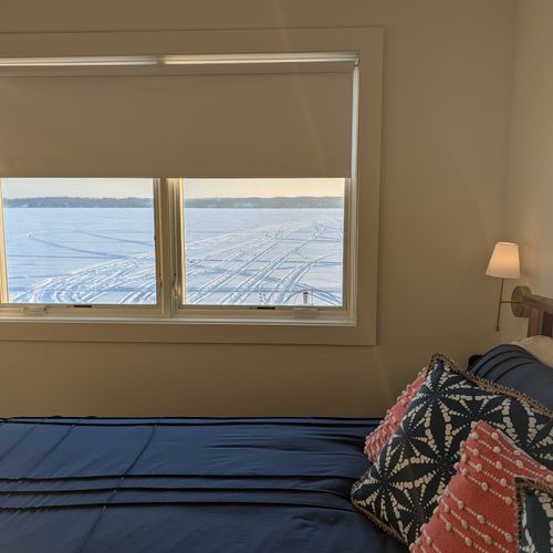 BEDROOM #1 (MAIN FLOOR):  Features a queen-size bed, ceiling fan, nightstands, nightlamps, dresser, mirror, private television, closet, and a great view of Crystal Lake!