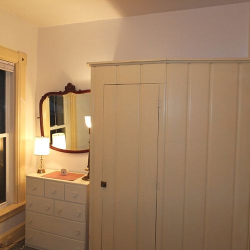 Bedroom #2 (main floor):  features a full-size bed, mirror, dresser, and closet.