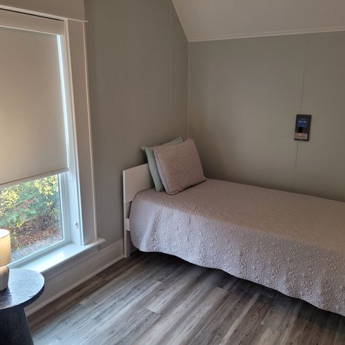 BEDROOM #4 (SECOND FLOOR):  Features 2 twin beds, window A/C unit (not shown), ceiling fan, nightstand, lamp, dresser, and a closet.