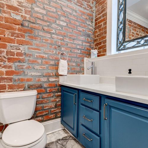 Bright bathroom vanity w/ sink & sleek blue cabinetry.