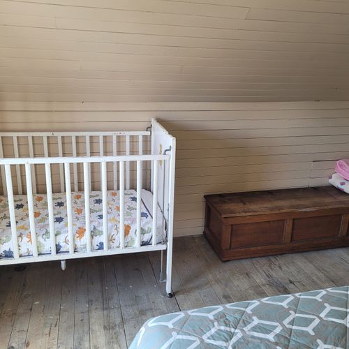 BEDROOM #3 (UPPER FLOOR):  Features a full-size bed, nightstand, dresser, mirror, baby crib, and closet.