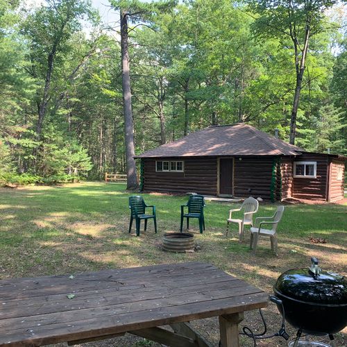 Overall:  the backyard at the cabin showing the fire pit, picnic table, and charcoal grill