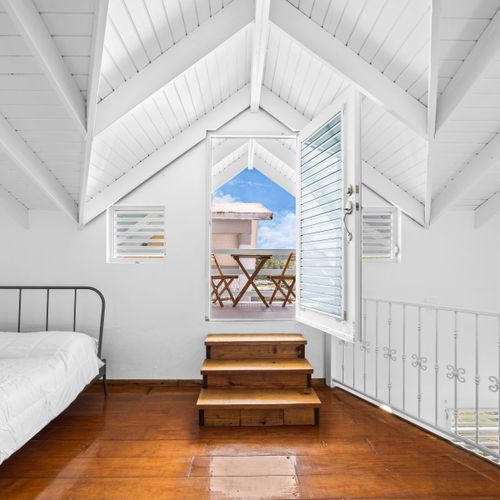 bedroom with private balcony, bed, soft linens and pillows