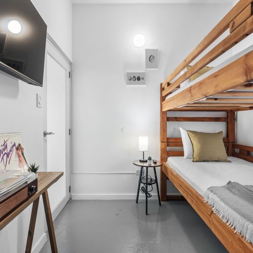 Descubra el confort minimalista en nuestra moderna habitación con literas, diseñada para ofrecer simplicidad y eficiencia.