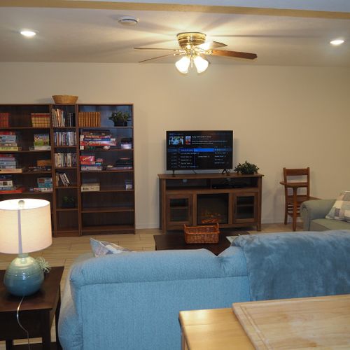 Living room:  the apartment has a very comfortable living room with a sleeper sofa, comfy chair, ceiling fan, table, and television.