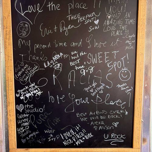 Chalkboard wall covered in guest notes & doodles — leave your own mark.