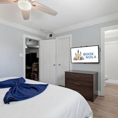 Unwind in a cozy bedroom w/ soft bedding & a wall-mounted TV.