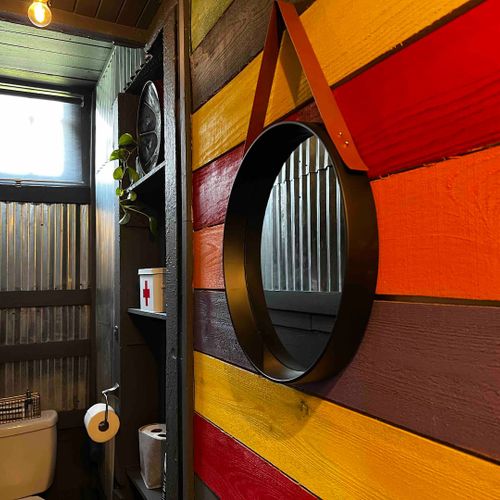 Stylish entryway w/ a round mirror & bold orange accent — a great first impression.