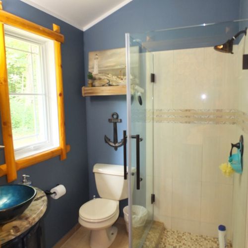 Bedroom #2:  the bedroom's en suite bathroom also includes a toilet, and glass shower.
