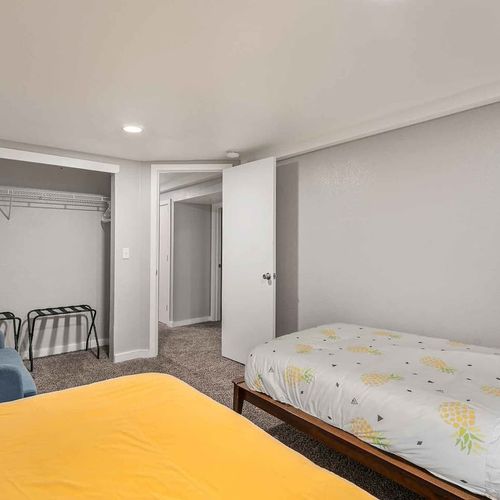 - alternate view reveals open closet space, wall hooks, and luggage rack for convenience
- bright linens and a clean design offer a calm and kid friendly atmosphere
- plenty of space for clothes, toys, or suitcases during longer stays