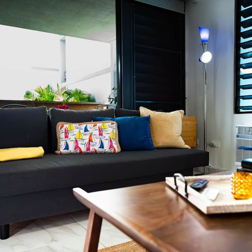 Unwind in style on this cozy sofa, ideal for lounging, reading, or enjoying a quiet moment. Thoughtful decor and natural light create a welcoming and relaxing atmosphere.