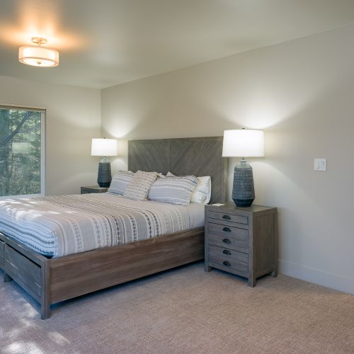Ensuite bathroom with custom-tiled shower and a double vanity, plus a walk-in closet are included with both guest bedrooms on lower level.
