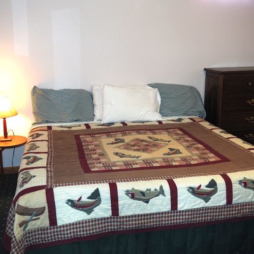 Bedroom #2 (lower level):  features a king-size bed, dresser, chair, table, and crib.