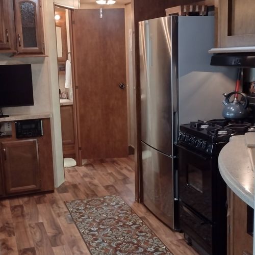 Kitchen:  the home has a cute little kitchen with a refrigerator, sink, counter, stove, oven, and microwave. There is also a collection of cooking and dining utensils provided.