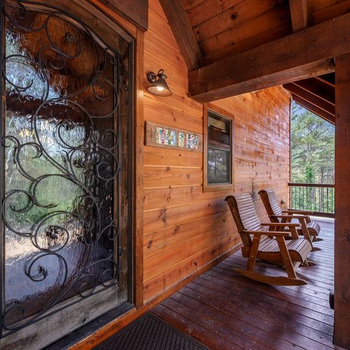 The front porch is accompanied by rocking chairs.