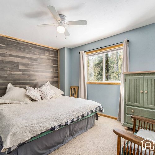 - peaceful bedroom with a plush king bed, wood accent wall, and forest views
- soft blue tones, cozy carpet, and natural light create a calming sleep space
- thoughtful details like the green armoire add warmth and rustic charm
