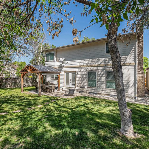 Lush backyard escape with covered deck dining, perfect for laid-back afternoons.