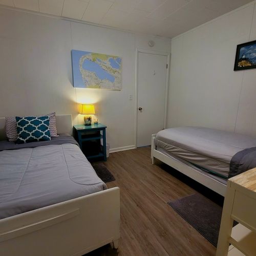 Bedroom #3:  bedroom #3 features two twin-size beds, a closet, and nightstands with lamps.