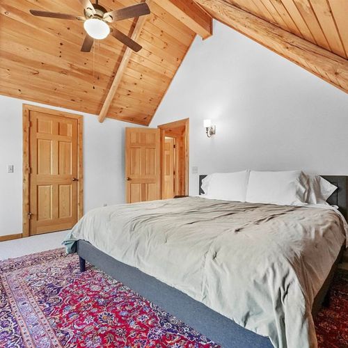 Bedroom #2 (second floor):  features a king-size bed, chair, dresser, ceiling fan, closet, and nightstand.