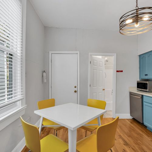 Airy dining nook w/ a clean white table, perfect for morning coffee or a home-cooked meal.