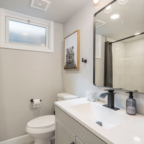 The downstairs hall bathroom offers a convenient walk-in shower and stylish vanity space, perfect for refreshing after a day of adventures.