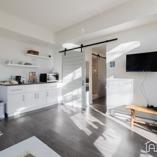 - whip up quick snacks or coffee in this compact kitchenette with all the essentials
- catch your favorite shows on the wall mounted tv or enjoy a cozy movie night
- modern barn doors lead to restful spaces, blending style and function seamlessly