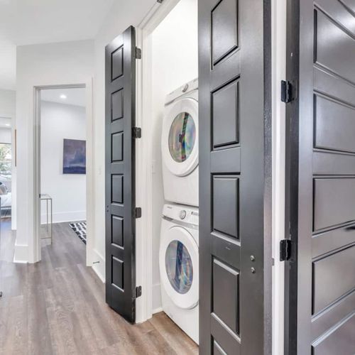Upstairs washer & dryer tucked neatly behind sleek black doors — so convenient.