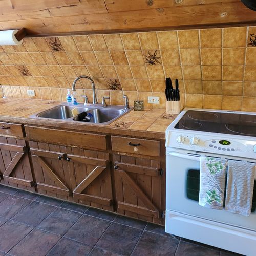 Kitchen:  features an electric range, sink, counter space, cabinets, refrigerator, microwave, and coffee maker. (no dishwasher though. )