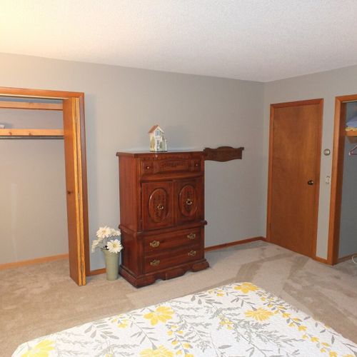 Bedroom #1:  features a queen-size bed, chair, nightstand, lamp, dresser, and 2 closets.