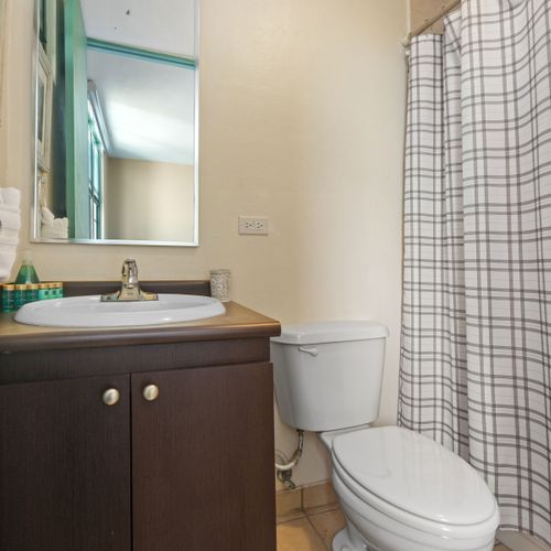 Step into our pristine bathroom, complete with a spacious countertop and refreshing shower.