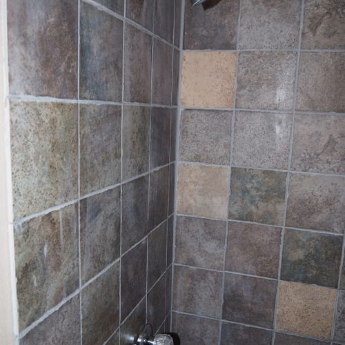 Bathroom:  features a shower and toilet. (note that there is no vanity, sink, or mirror in the bathroom. )