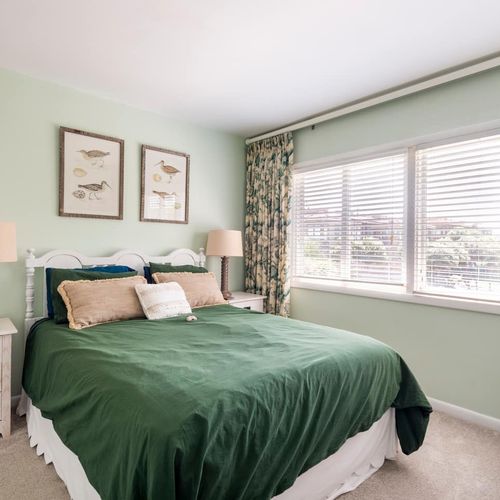 Relax in a comfortable queen-sized bed in the second bedroom with tv, dresser and accent seating for your convenience.