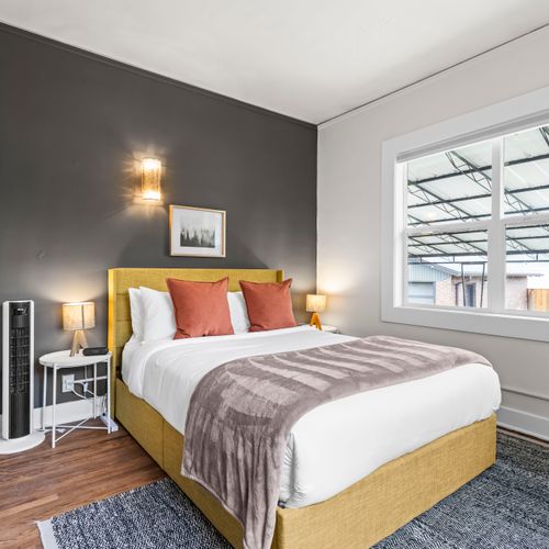 Comfortable queen bed in the second bedroom, with airy windows and blackout shades for nighttime comfort.