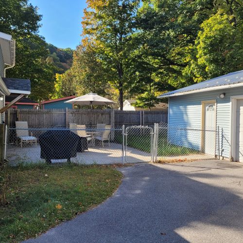 Exterior:  the fully fenced-in backyard next to the driveway and detached garage.
