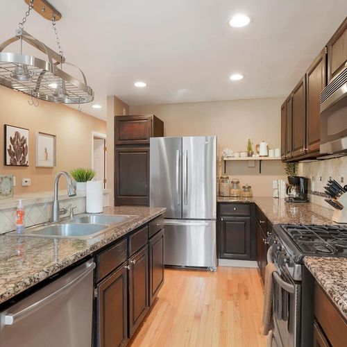 - sleek kitchen with dark cabinetry, granite countertops, and stainless appliances
- plenty of prep space and stylish lighting make this a dream for cooking enthusiasts
- everything you need is at your fingertips in this polished, modern space
