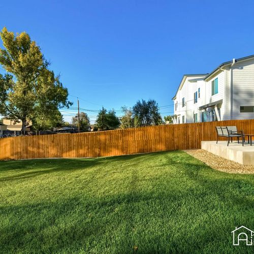 - view of the spacious fenced yard looking back toward the home and patio seating
- great layout for entertaining, sunbathing, or enjoying a summer bbq
- fully enclosed green space offers safety and fun for families and pets alike