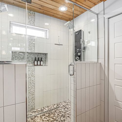 Spa-like bathroom featuring sleek tile work and a rainfall shower head.