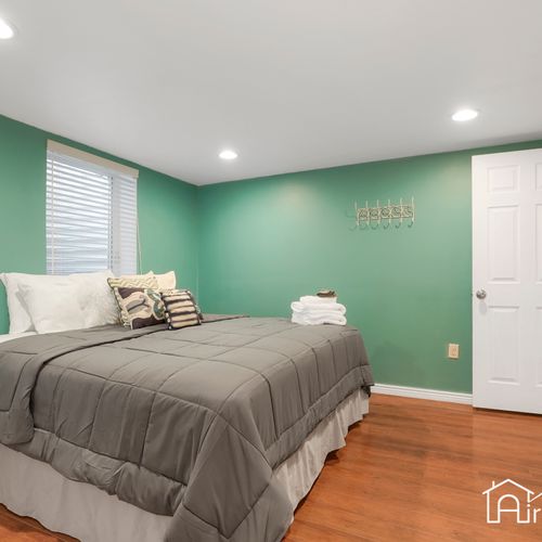 This downstairs bedroom features a queen-sized mattress and lots of light from the egress window.