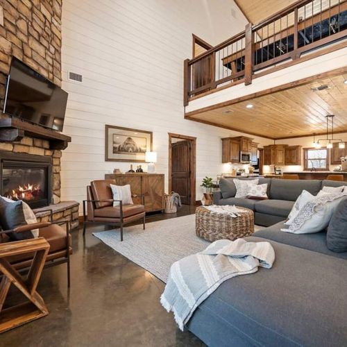 An oversized sectional placed around the floor to ceiling fireplace.